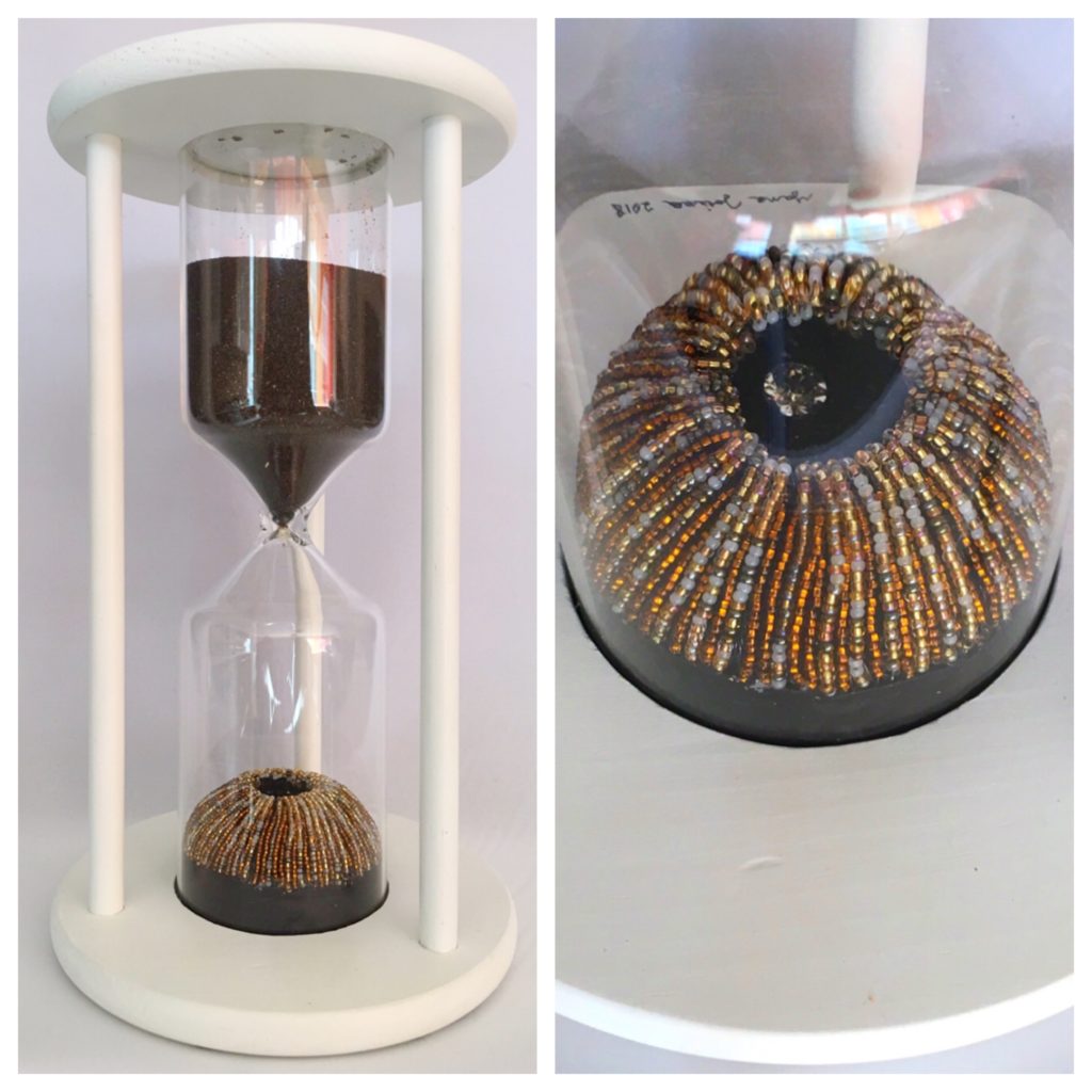 symbolic hourglass filled with black sand and an iris of a human eye