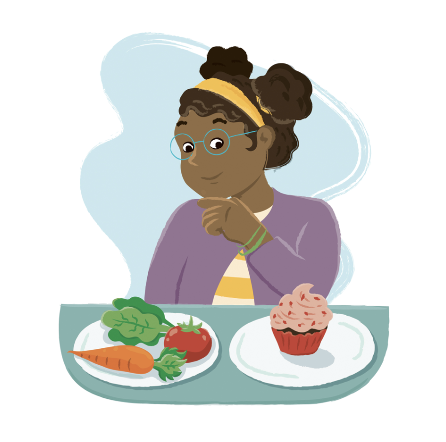 A girl sits with two plates of food. One has healthy vegetables and a piece of fruit, the other has a cupcake.