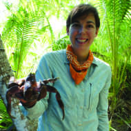 A photo of illustrator Sara Lynn Cramb holding a giant spider